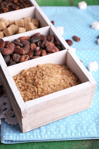 Caja de madera con set de café y granos de cacao, terrones de azúcar sobre fondo de madera —  Fotos de Stock