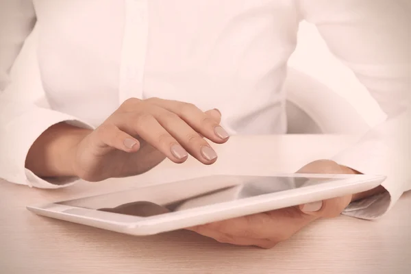 Woman using digital tablet on light background Stock Picture