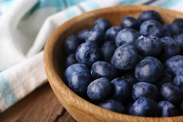 Trä skål med blåbär på servett på trä bakgrund närbild — Stockfoto