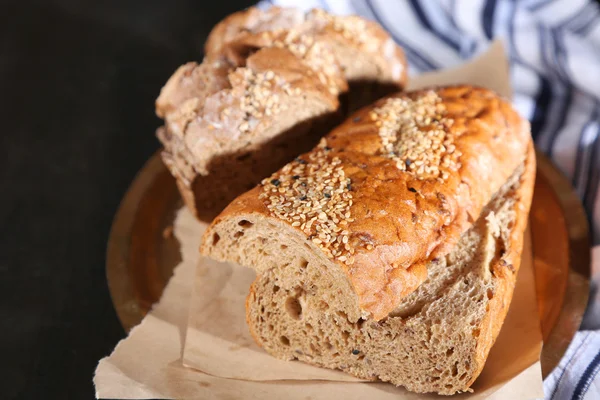 Pão fresco na bandeja no fundo de madeira escura — Fotografia de Stock