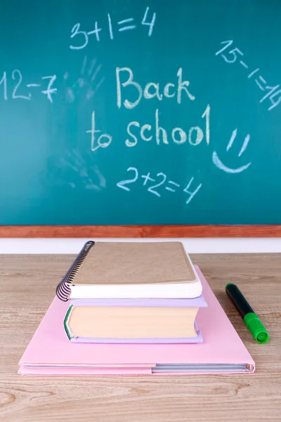 Skolan levererar på bordet på blackboard bakgrund — Stockfoto