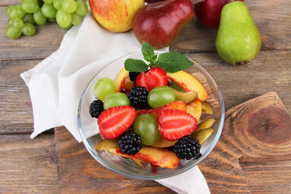 Frischer, schmackhafter Obstsalat auf Holztisch — Stockfoto