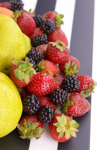 Спелые груши и ягоды на полосатом фоне — стоковое фото