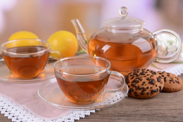 Teapot and cups of tea on table on light background — Stock Photo, Image