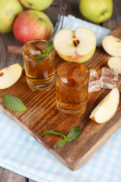 Stilleben med läckra apple cider på fat och färska äpplen — Stockfoto