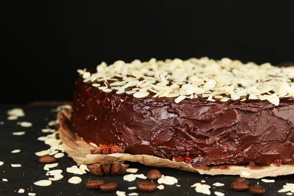 Finom csokoládé torta mandula, fából készült tábla, sötét háttér — Stock Fotó