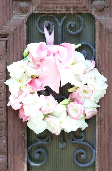 Bela grinalda de flores penduradas na velha porta de madeira — Fotografia de Stock