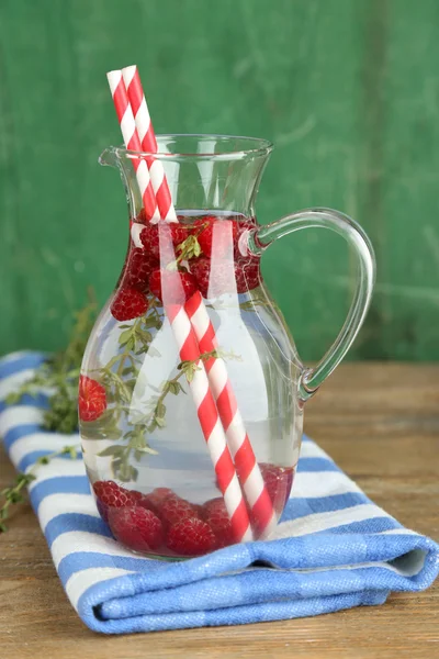 Tasty cool beverage with raspberries and thyme, on light background — Stock Photo, Image