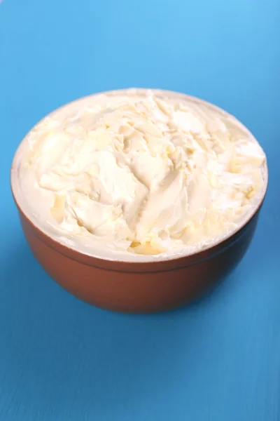 Frische hausgemachte Butter in Schüssel, auf farbigem Holzhintergrund — Stockfoto