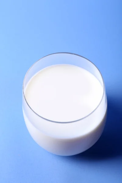 Leche en vidrio sobre fondo azul — Foto de Stock