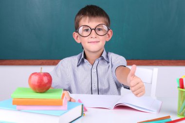 Okul çocuğu sınıfta oturuyor.
