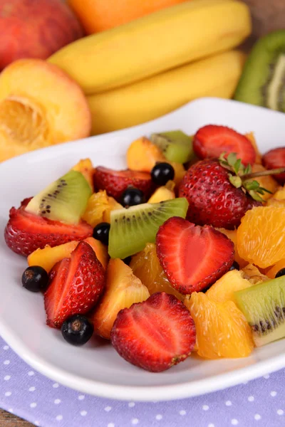 Fresh fruits salad on plate with on table close up — Stock Photo, Image