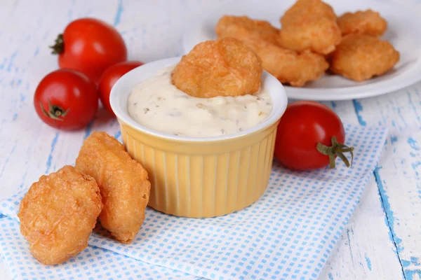 Kipnuggets met saus op tabel close-up — Stockfoto