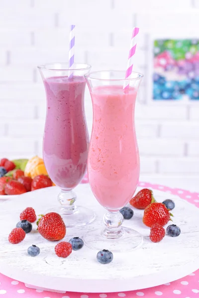 Heerlijke berry cocktails op tabel op bakstenen muur achtergrond — Stockfoto