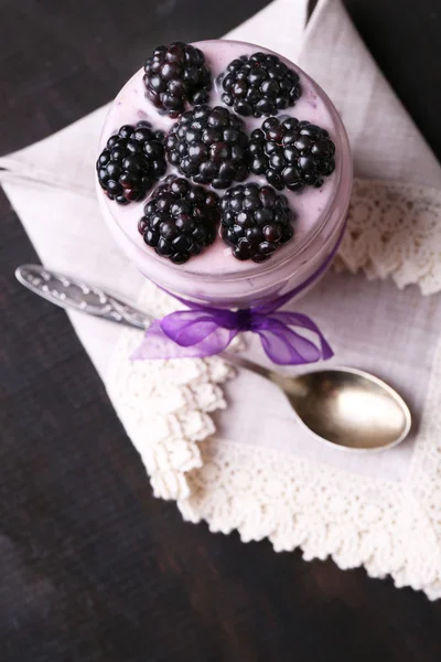 Gezond ontbijt - yoghurt met bramen en muesli geserveerd in glazen pot, op donkere houten achtergrond — Stockfoto