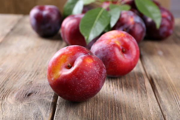 Süße Pflaumen auf hölzernem Hintergrund — Stockfoto