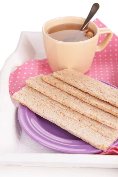 Crispbreads na placa e xícara de chá na bandeja de madeira de perto — Fotografia de Stock
