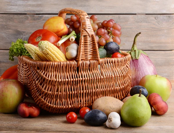 Verse biologische groenten en fruit op houten ondergrond — Stockfoto