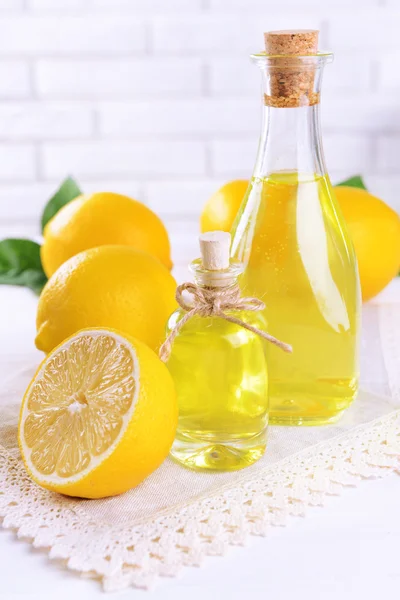 Zitronenöl auf dem Tisch auf hellem Hintergrund — Stockfoto