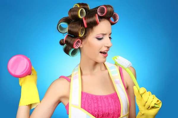Beautiful girl in hair curlers on blue background — Stock Photo, Image