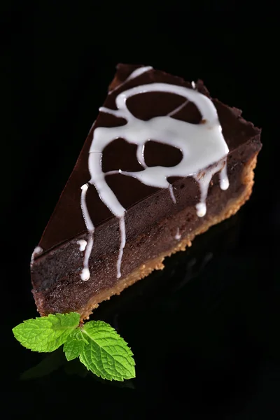 Pedazo de pastel de chocolate con hojas de menta en la mesa de cristal —  Fotos de Stock