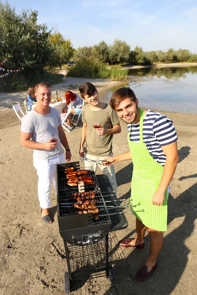 Venner som har grillfest – stockfoto