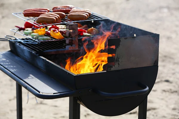 Saucisses et légumes sur barbecue, en plein air — Photo