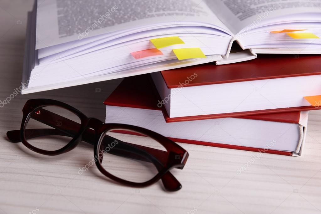 Books with bookmarks and glasses