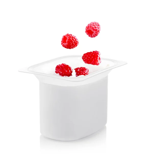 Delicious fresh raspberry falling into yogurt isolated on white — Stock Photo, Image