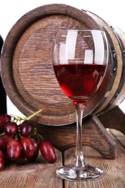 Kırmızı Şarap kadehi, üzüm ve beyaz arka plan üzerinde ahşap masa üzerinde varil