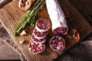 Salam kesme tahtası üzerinde çul peçete ahşap arka plan üzerinde üzerinde Fransız