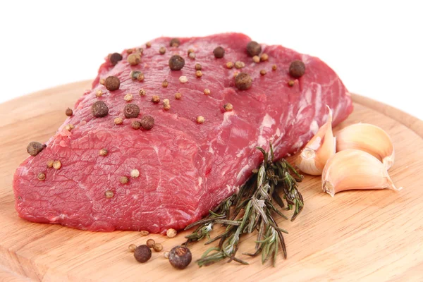 Raw beef meat with spices on wooden cutting board close up — Stock Photo, Image