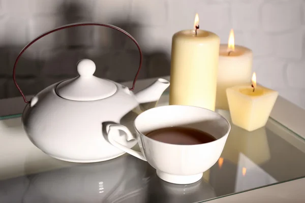 Tè in tazza e teiera e candele — Foto Stock
