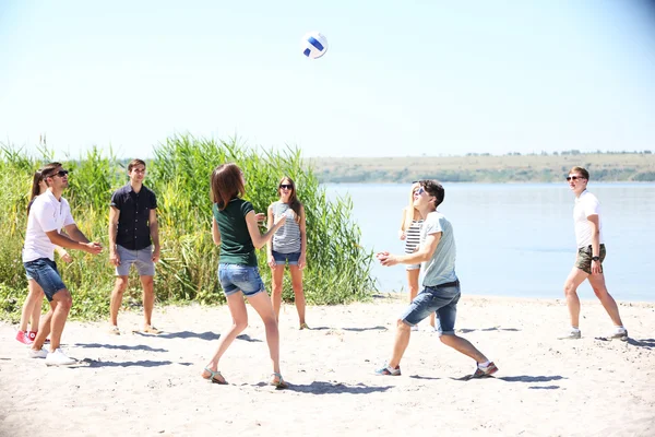 Jóvenes jugando voleibol en la playa —  Fotos de Stock