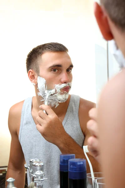 Junger Mann rasiert sich — Stockfoto