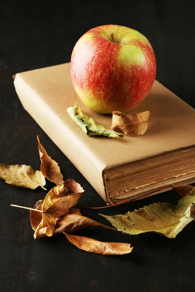 Apfel mit Büchern und trockenen Blättern — Stockfoto