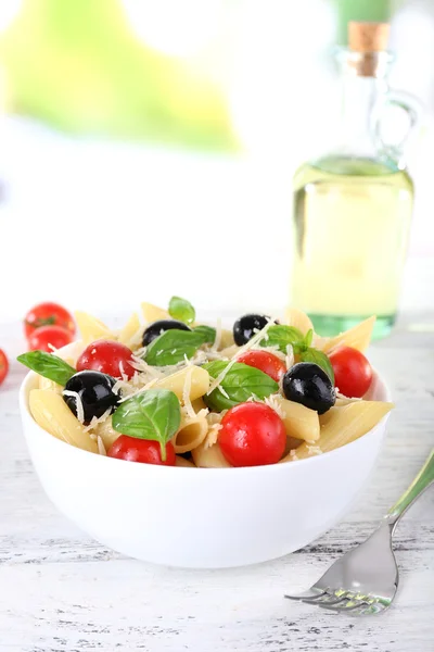 Pasta con tomates, aceitunas y hojas de albahaca — Foto de Stock