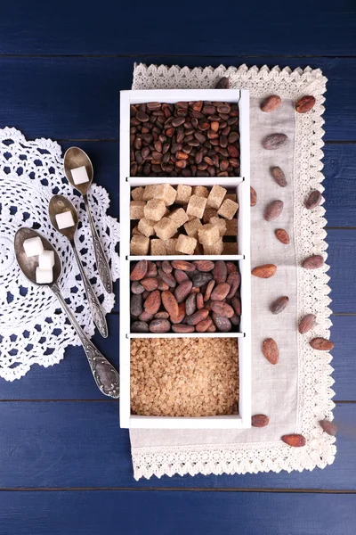 Wooden box with set of coffee and cocoa beans, sugar cubes on wooden background — Stock Photo, Image