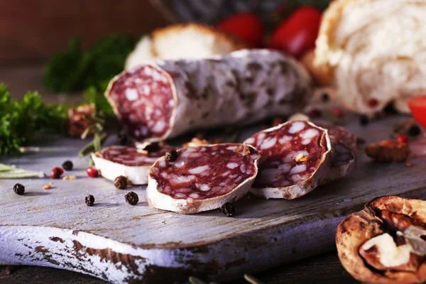 Francuski salami, pomidory, pietruszka i chleb na deska do krojenia na drewniane tła — Zdjęcie stockowe
