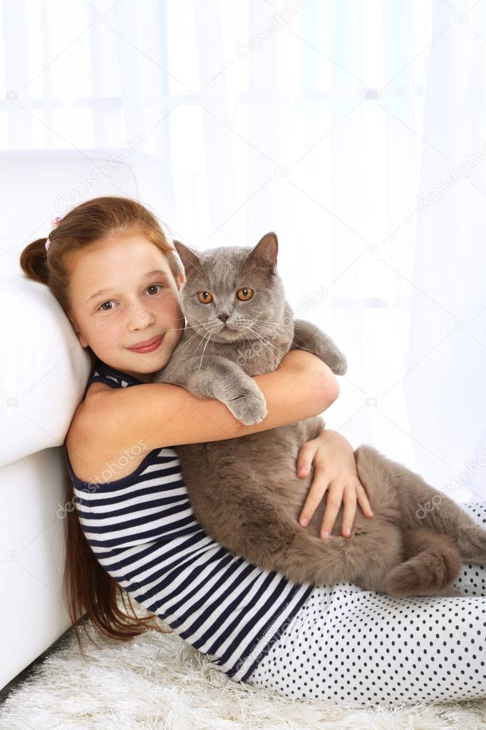 Güzel küçük bir kız ile kedi odada Stok fotoğrafçılık ©belchonock