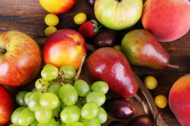 farklı meyveler ve meyve tepsi üzerinde ahşap masa yakın çekim