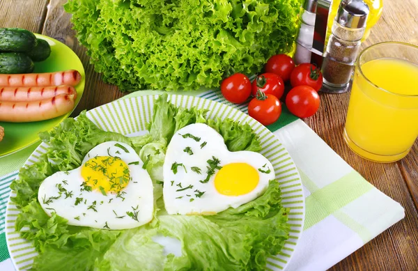 Яичница с колбасой и овощами на тарелке на салфетке — стоковое фото