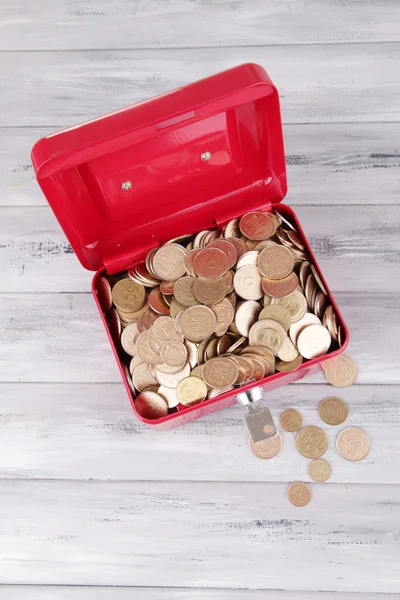 Maleta abierta roja rectangular con monedas ucranianas sobre mesa de madera —  Fotos de Stock