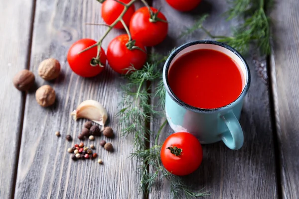 Zelfgemaakte tomatensap in kleur mok, specerijen en verse tomaten op houten achtergrond — Stockfoto