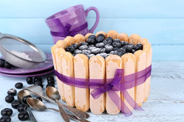 Tasty cake Charlotte with blueberries on blue wooden table — Stock Photo, Image