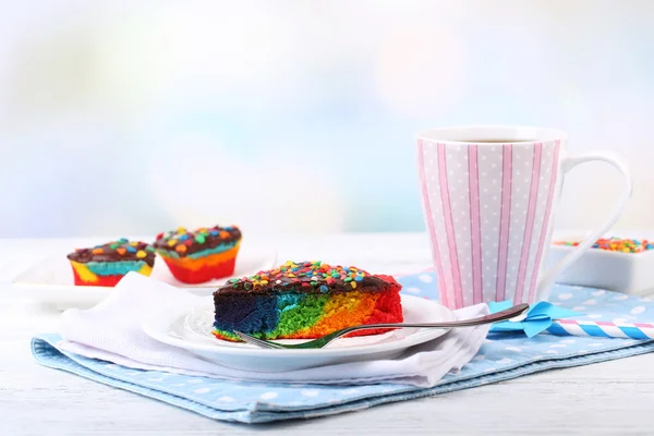 Torta deliziosa arcobaleno sul piatto, sulla tavola, su sfondo chiaro — Zdjęcie stockowe