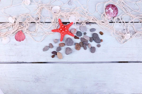 Decor of seashells and seastar close-up on blue wooden table — Stock fotografie