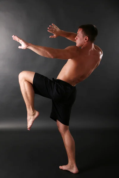 Handsome muscle young man on dark background — Stock Photo, Image