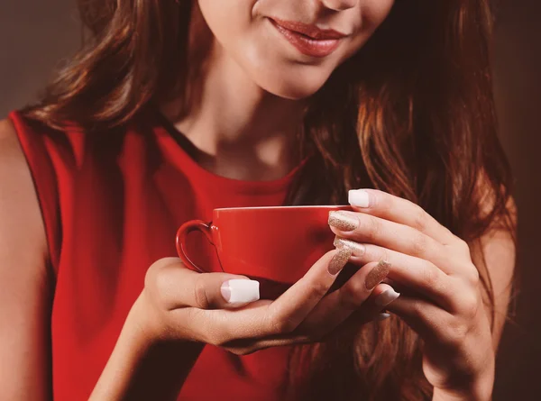 Beautiful young girl with cup of coffee on brown background — Stock Photo, Image