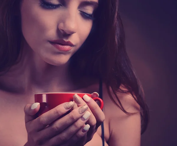茶色の背景にコーヒーのカップを持つ美しい少女 — ストック写真
